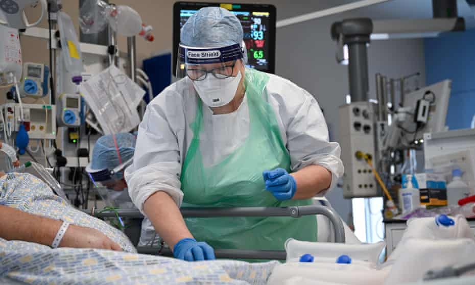 A member of staff at University Hospital Monklands in Airdrie, Scotland, attends to a Covid patient
