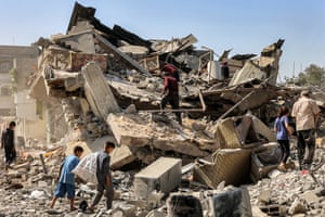 People walk among the rubble