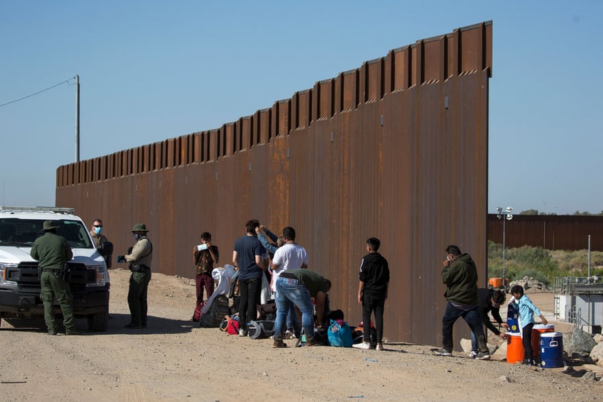 Migrants from Columbia wait to be processed after turning themselves over to authorities at the US-Mexico border on 12 May 2021 in Yuma, Arizona.