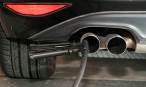 A hose for an emission test is fixed in the exhaust pipe of a Volkswagen Golf diesel car