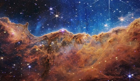 Žvaigždėmis išmargintas kalnų ir slėnių peizažas iš tikrųjų yra šalia esančio jauno, žvaigždes formuojančio regiono, vadinamo NGC 3324, pakraštys Karinos ūke.