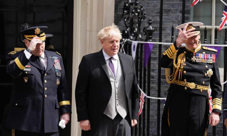 Boris Johnson poses for a photograph with military personnel outside 10 Downing Street
