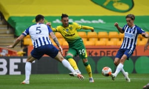 The Canaries’ Josip Drmic passes between the Seagulls’Leandro Trossard and Lewis Dunk.