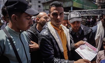 A Palestinian holds a warning leaflet dropped by Israeli planes 