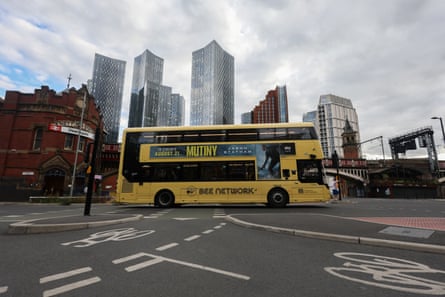A yellow Bee network bus passes Deansgate railway station, in Manchester, 24 August 2026.