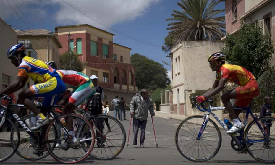 Cyclists during a street race in front of a villa influenced by Italian avant-garde architecture in Asmara.