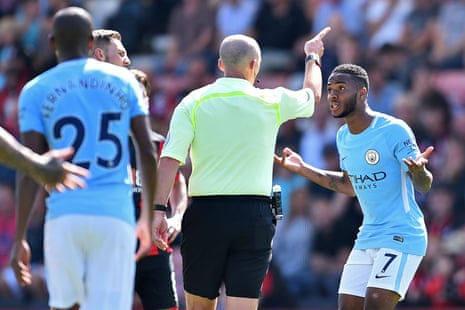 Raheem Sterling looks perplexed as Mike Dean orders him off the pitch after showing the City goalscorer a second yellow card, for going into the crowd whilst celebrating his goal.