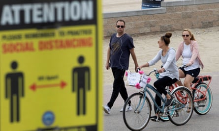 People choose not to wear face masks the boardwalk in Huntington Beach, California, on 1 July.