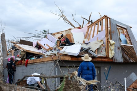 A toppled home, with the wood frame and cement foundation visible.