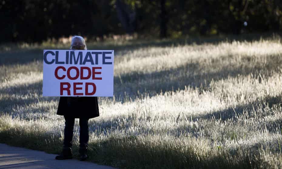 A protester holds a sign reading 'Climate code red'