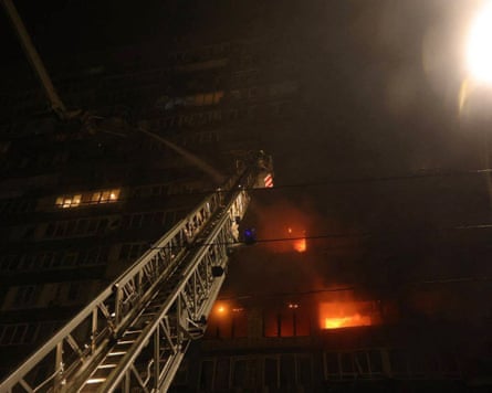 Firefighters work to extinguish fires in a residential building in Kyiv after the Russian attack