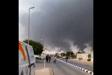A photo of a road with dark smoke rising in the background