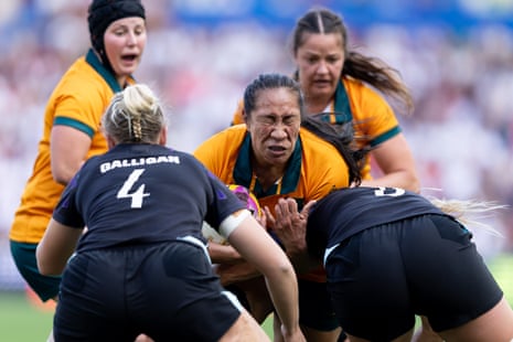 Siokapesi Palu of Australia attempts to go past Rosie Galligan and Alex Matthews of England.