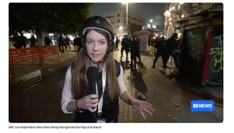 A woman holding a microphone with a hard helmet on.