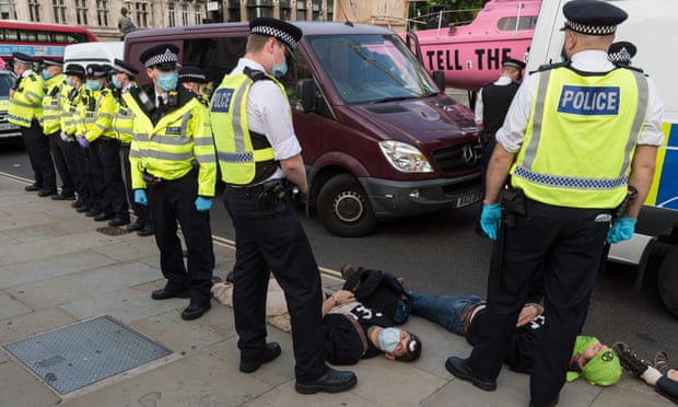 Activists from Extinction Rebellion lie on the ground after being arrested in Parliament Square following a march through central London on 10 September 2020.
