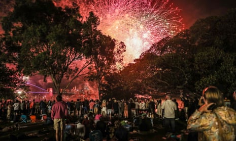 La gente ve los fuegos artificiales a las 9 p.m. el 31 de diciembre de 2022 en Sydney, Australia