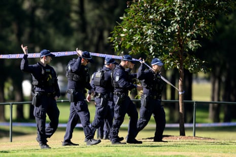 A group of police officers walk on grass.
