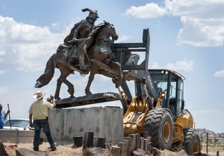 Rio Arriba county workers remove the bronze statue of Juan de Oñate in front of a cultural center in Alcalde, New Mexico.