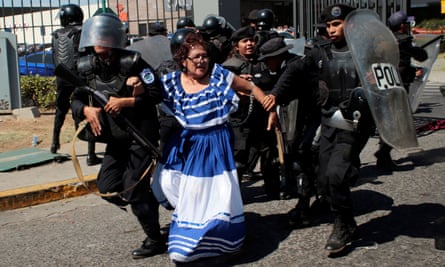 Riot police detain an anti-government protester in traditional costume.