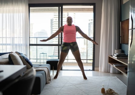 A mature woman doing jumping jacks in her apartment