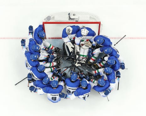 The Italy team gather for a huddle in front of their goal during their ice hockey preliminary round match between against China in Cortina.