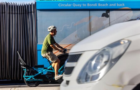 A man makes his way though traffic on Oxford Street, Paddington, Sydney on his bike.