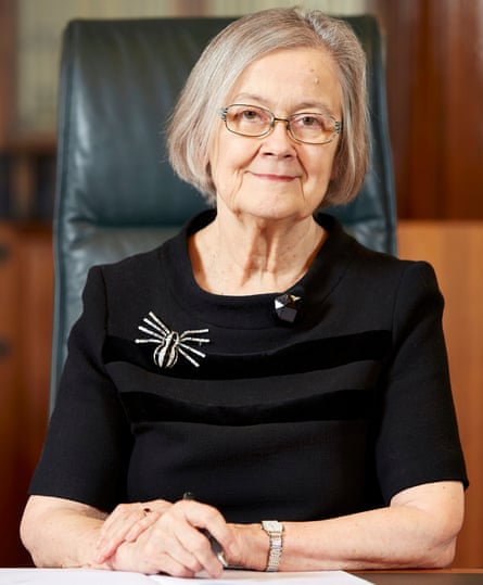 Lady Hale, smiling, with a large spider brooch on her dress that symbolised wickedness and web-wearving