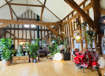 A moped, low chest of drawers, plants in medieval-timbered living room with hardware floors