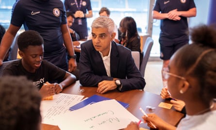 Sadiq Khan sits at a table with children