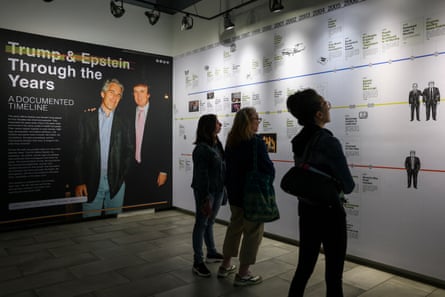 People look at documents on wall of exhibition