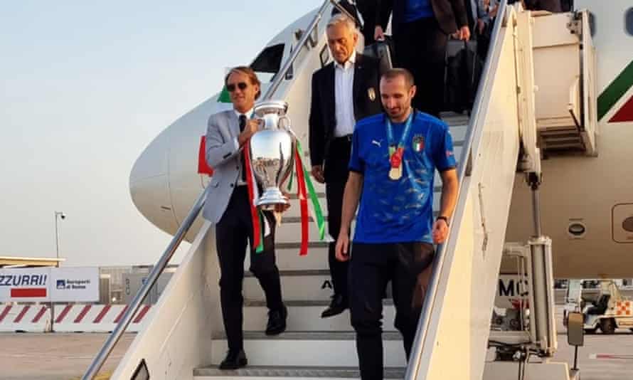 Roberto Mancini takes the trophy out of the plane