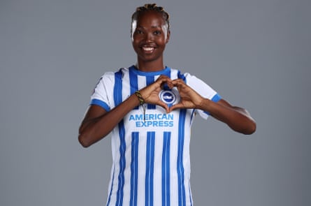 Aisha Masaka makes a heart around the Brighton badge on her kit