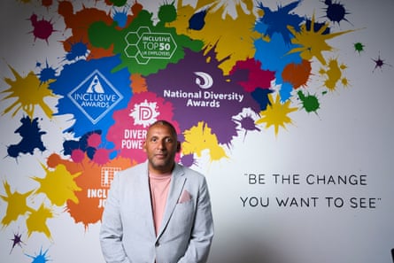 Paul Sesay in front of a National Diversity Awards poster, with words ‘Be The Change You Want to See’