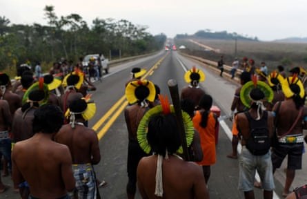 Members of the Kayapo Indigenous group walk along a highway on the outskirts of Novo Progresso