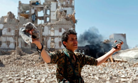 A Huthi rebel inspects bomb damage in Sana’a, Yemen.