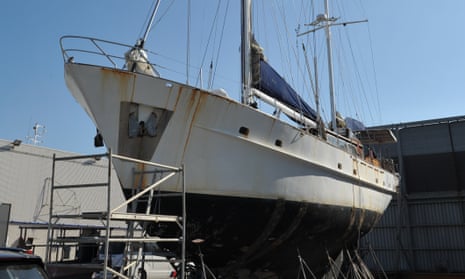 A beached yacht on drydock behind police tape