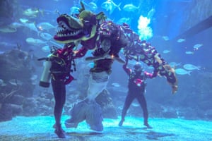 Divers wearing costumes perform a traditional lion dance at Jakarta aquarium and safari conservation park, Indonesia