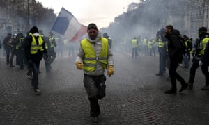 A demonstrator wearing a yellow vest grimaces through teargas in Paris.