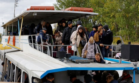 Civilians leave a ferry in Oleshky.