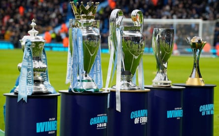 The FA Cup, Premier League, European Cup, League Cup and Club World Cup trophies on stands at the Etihad before the game