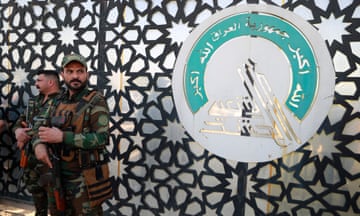 Members of Iraq's Hashed al-Shaabi stand guard at the entrance of their headquarters in Baghdad in January 2024.