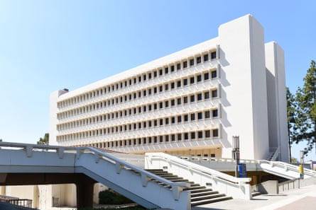 A maybe six-story white building with six long rows of black windows.