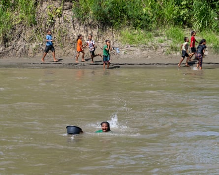 A teenage girl swims across a crocodile-filled river to reach a school