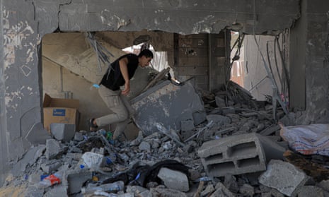 A man walks through the rubble of a destroyed building after an Israeli airstrike in the southern Gaza Strip city of Rafah
