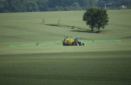 A tractor sprays pesticide onto a field of wheat near Kleptow, Germany