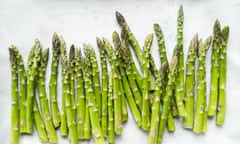 Close up of fresh bright green asparagus on white parchment paper