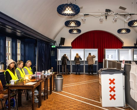 Poll workers wait as people prepare their ballots in voting booths at a polling station in Amsterdam, the Netherlands.