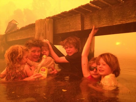 A woman and her five grandchildren take refuge in the water under a jetty from wildfires in Tasmania