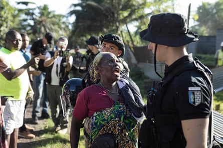 A woman confronts a French gendarme during the demolition of an informal settlement in Longoni, Mamoudzou, 17 April