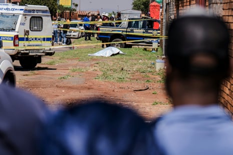 Onlookers watch police recover a womanâÂÂs body